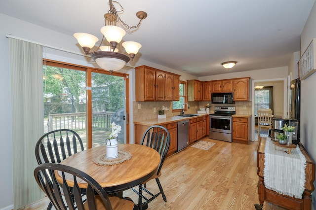 911 Woodland Hills Rd, Batavia, IL 60510 - kitchen featuring stainless steel appliances, a sink, a chandelier, light countertops, and plenty of natural light