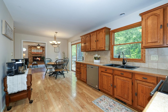 911 Woodland Hills Rd, Batavia, IL 60510 - kitchen featuring a sink, stainless steel dishwasher, light countertops, brown cabinetry, and light wood-style floors