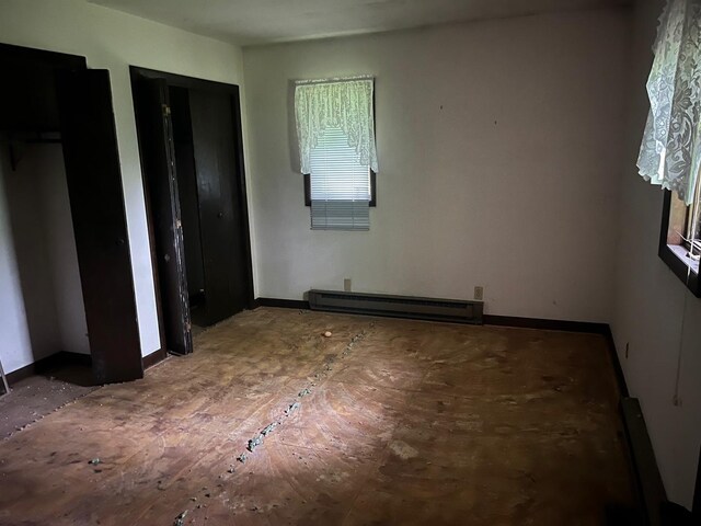 4528 1369th Rd, Earlville, IL 60518 - unfurnished bedroom with a baseboard heating unit and multiple closets