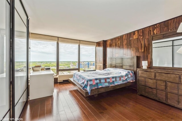 bedroom featuring dark wood-style flooring and wooden walls