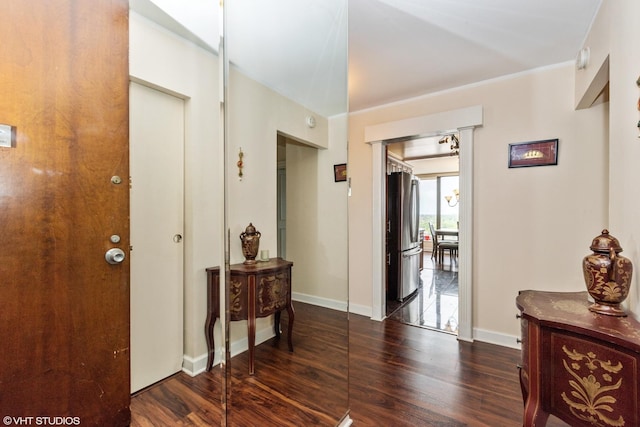 hall featuring dark wood-style flooring and baseboards