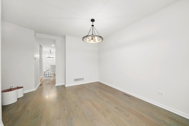 2569 Essex Dr, Northbrook, IL 60062 - unfurnished room with wood finished floors, baseboards, and a chandelier