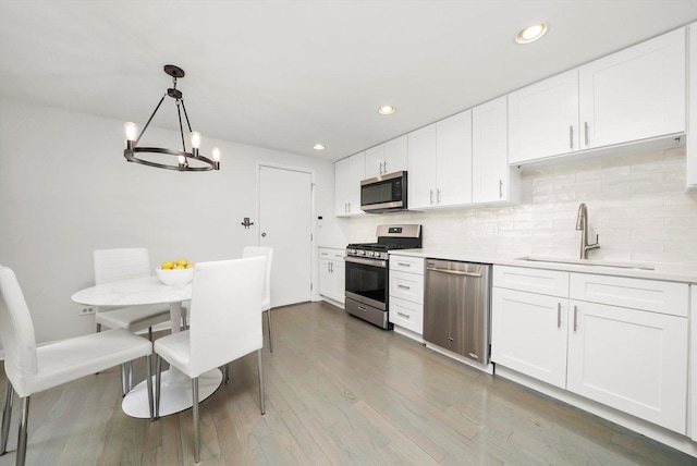2569 Essex Dr, Northbrook, IL 60062 - kitchen with stainless steel appliances, a sink, light countertops, recessed lighting, and tasteful backsplash