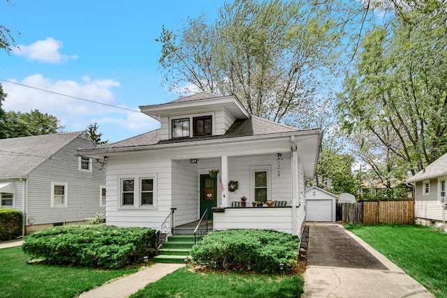 629 S Union St, Aurora, IL 60505 - view of front facade featuring covered porch, a garage, an outdoor structure, driveway, and a shingled roof