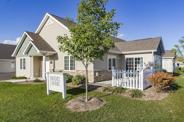 2164 Waterbury Ln W Unit 2164, Sycamore, IL 60178 - view of front of property with a front yard, a shingled roof, stone siding, and a patio