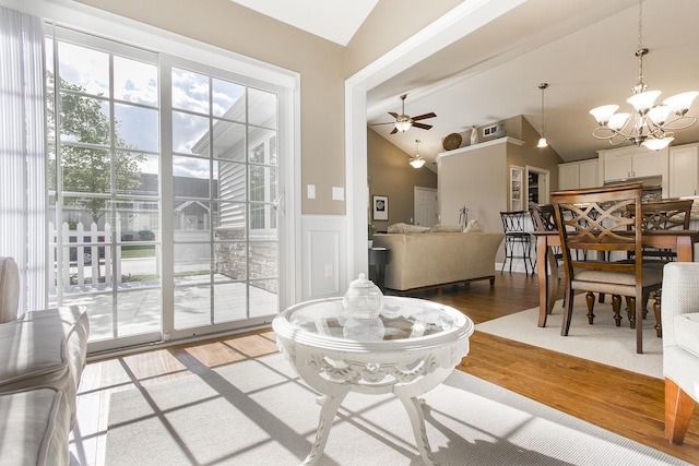 2164 Waterbury Ln W Unit 2164, Sycamore, IL 60178 - living room featuring vaulted ceiling, light wood finished floors, a chandelier, wainscoting, and ceiling fan