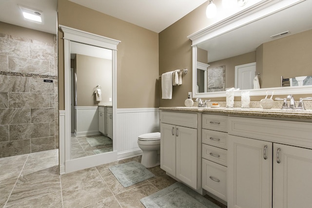 2164 Waterbury Ln W Unit 2164, Sycamore, IL 60178 - bathroom featuring double vanity, walk in shower, toilet, and a wainscoted wall