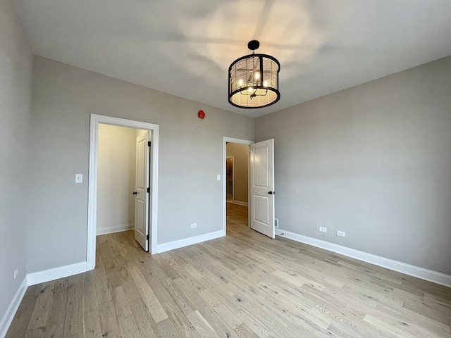LOTT315929 Prairie View Ct, New Lenox, IL 60451 - unfurnished bedroom featuring a chandelier, light wood finished floors, a spacious closet, and baseboards