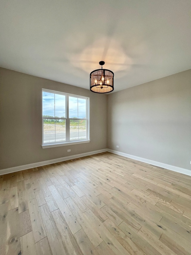 LOTT315929 Prairie View Ct, New Lenox, IL 60451 - unfurnished room with a chandelier, light wood-style floors, and baseboards