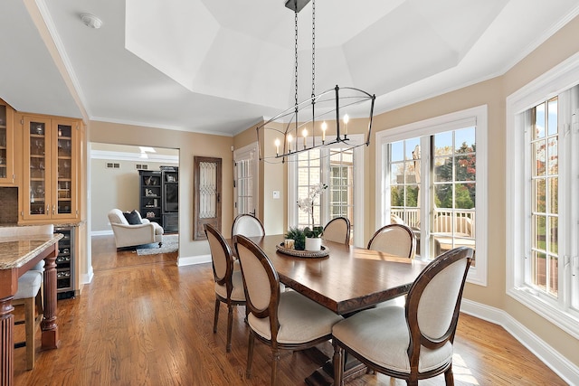 12000 W Donegal Ln, New Lenox, IL 60451 - dining area featuring wine cooler, wood finished floors, a chandelier, a tray ceiling, and crown molding
