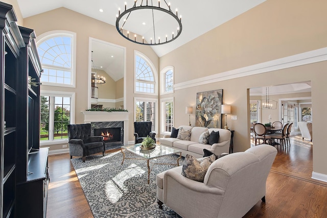 12000 W Donegal Ln, New Lenox, IL 60451 - living area featuring a chandelier, healthy amount of natural light, high vaulted ceiling, dark wood-style flooring, and a premium fireplace
