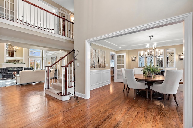 12000 W Donegal Ln, New Lenox, IL 60451 - dining room with wood finished floors, a chandelier, a fireplace, crown molding, and stairway