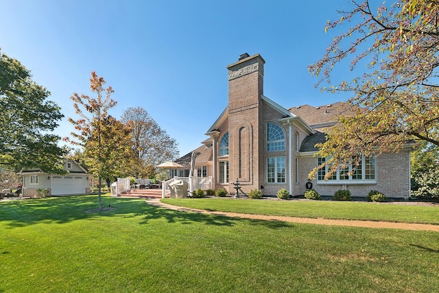 12000 W Donegal Ln, New Lenox, IL 60451 - back of house with a chimney, a lawn, a deck, brick siding, and a garage