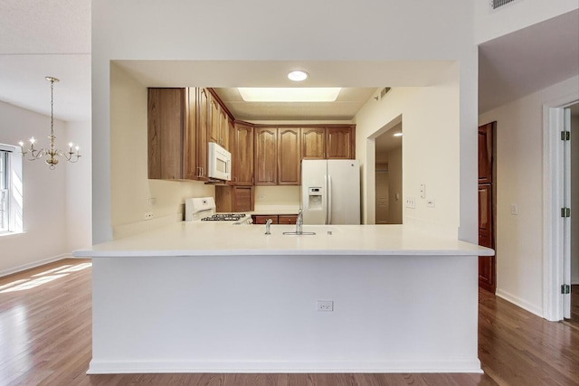 200 N Addison Ave Unit 306, Elmhurst, IL 60126 - kitchen featuring white appliances, a peninsula, wood finished floors, and light countertops
