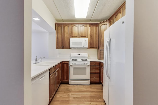 200 N Addison Ave Unit 306, Elmhurst, IL 60126 - kitchen with white appliances, a sink, light wood-type flooring, light countertops, and brown cabinetry