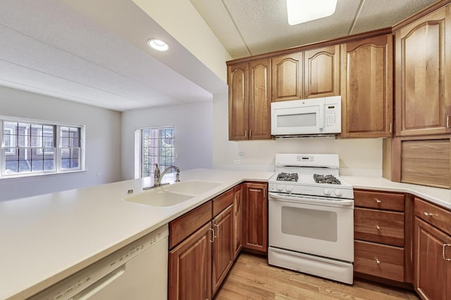 200 N Addison Ave Unit 306, Elmhurst, IL 60126 - kitchen featuring white appliances, a sink, light wood-style flooring, light countertops, and brown cabinetry