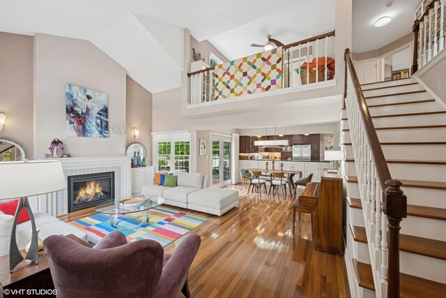 640 Yardley Ln, Hoffman Estates, IL 60169 - living area featuring hardwood / wood-style flooring, high vaulted ceiling, stairs, a tiled fireplace, and a ceiling fan