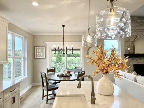 15959 Prairie View Ct Unit T6, New Lenox, IL 60451 - dining area featuring a fireplace, light wood-type flooring, baseboards, crown molding, and a chandelier