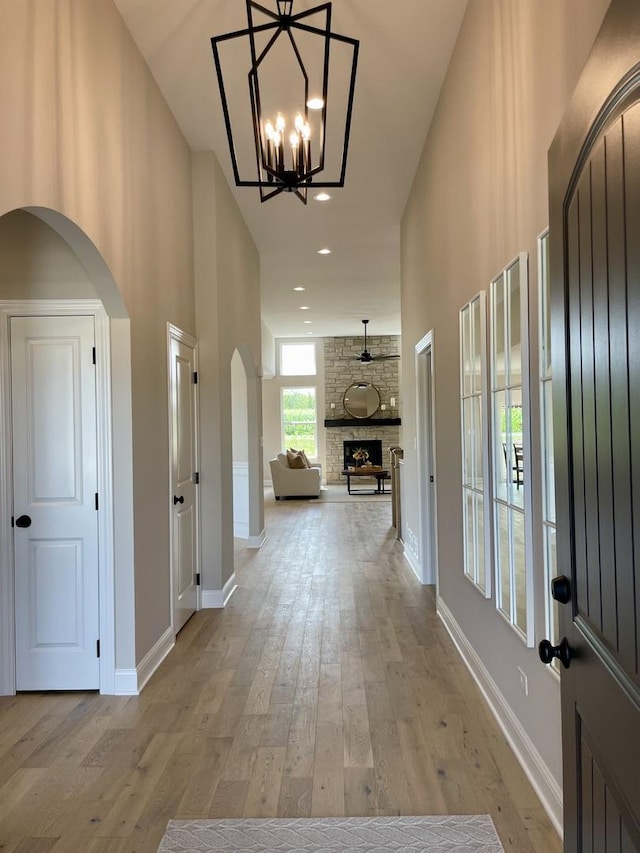 15959 Prairie View Ct Unit T6, New Lenox, IL 60451 - entryway with arched walkways, light wood-style floors, baseboards, a chandelier, and a fireplace