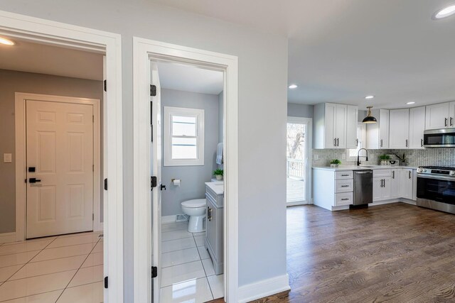 22W046 Mccormick Ave, Glen Ellyn, IL 60137 - kitchen featuring stainless steel appliances, a sink, light countertops, white cabinets, and plenty of natural light