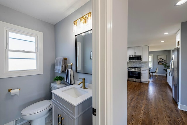 22W046 Mccormick Ave, Glen Ellyn, IL 60137 - bathroom with wood finished floors, toilet, decorative backsplash, recessed lighting, and vanity