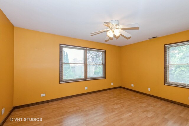 8747 Merrimac Ave, Oak Lawn, IL 60453 - unfurnished room with healthy amount of natural light, light wood-style floors, a ceiling fan, and baseboards