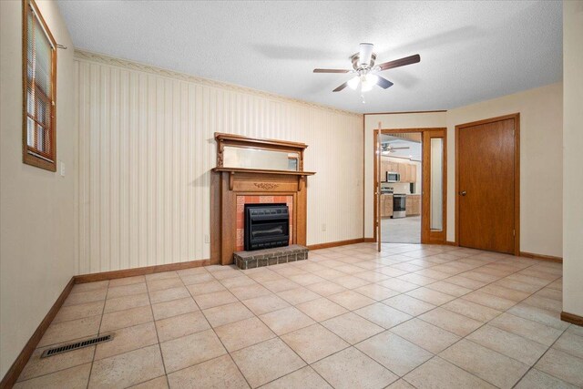 8491 Surrey Cir, Bloomington, IL 61705 - unfurnished living room with a ceiling fan, a tile fireplace, baseboards, and a textured ceiling