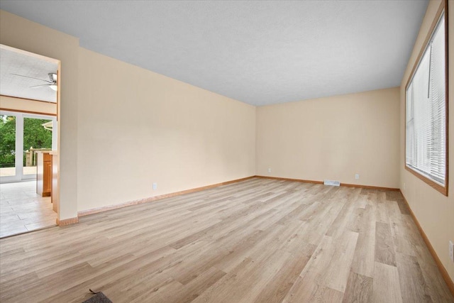 8491 Surrey Cir, Bloomington, IL 61705 - spare room featuring light wood-style flooring, ceiling fan, and baseboards