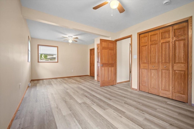 8491 Surrey Cir, Bloomington, IL 61705 - unfurnished bedroom featuring light wood-type flooring, baseboards, ceiling fan, and a closet