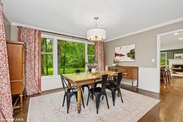21298 N Andover Rd, Kildeer, IL 60047 - dining space featuring dark wood-type flooring, crown molding, a chandelier, a glass covered fireplace, and baseboards