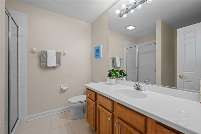 36W703 Whispering Trl, Saint Charles, IL 60175 - bathroom with tile patterned floors, baseboards, toilet, vanity, and a tile shower