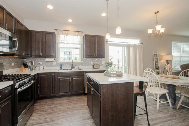 1901 Taos Ln, Volo, IL 60020 - kitchen featuring stainless steel appliances, a sink, a breakfast bar area, light wood finished floors, and recessed lighting