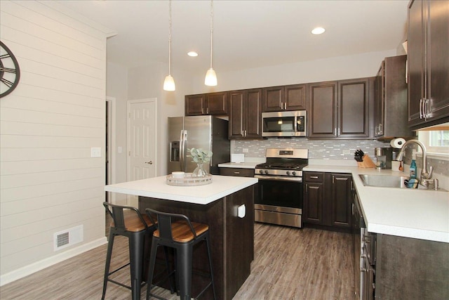 1901 Taos Ln, Volo, IL 60020 - kitchen featuring appliances with stainless steel finishes, a sink, wood finished floors, dark brown cabinetry, and recessed lighting
