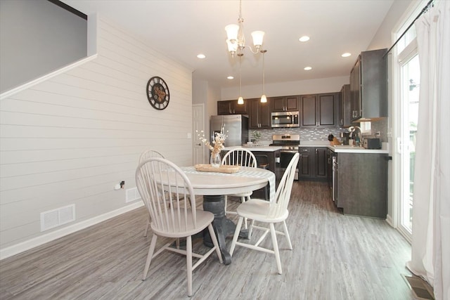 1901 Taos Ln, Volo, IL 60020 - dining space with light wood-style floors, a chandelier, baseboards, recessed lighting, and wooden walls
