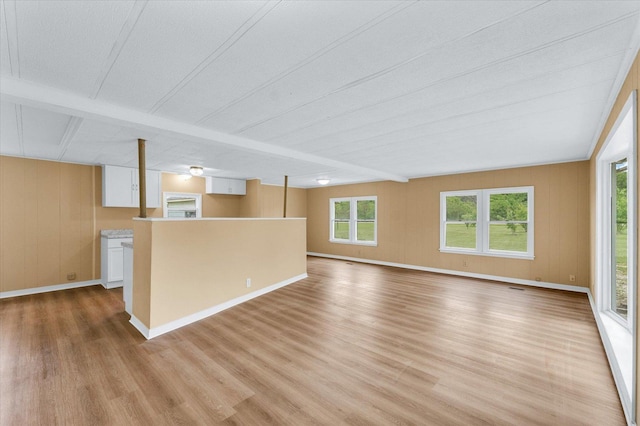 116 Seminole Ln, Loda, IL 60948 - unfurnished living room featuring light wood finished floors, healthy amount of natural light, baseboards, and beam ceiling