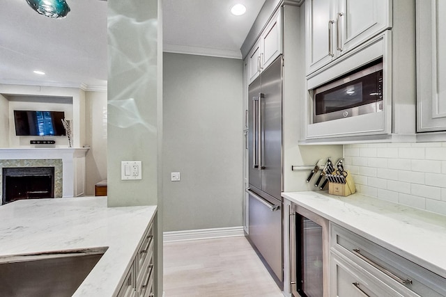 460 W Deming Pl Unit 1E, Chicago, IL 60614 - kitchen featuring built in appliances, crown molding, wine cooler, baseboards, and tasteful backsplash