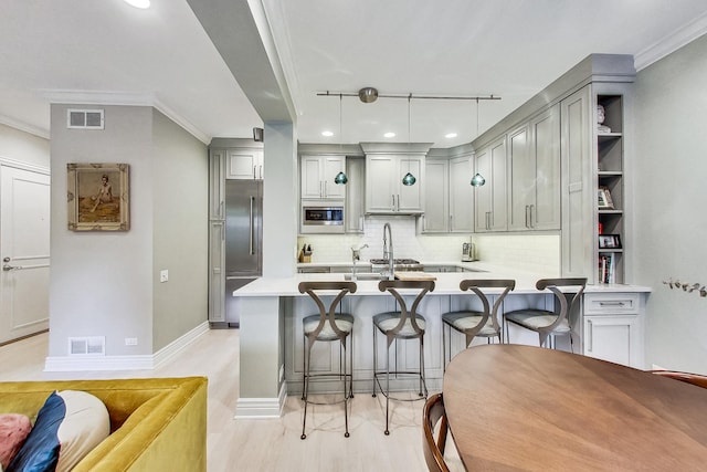 460 W Deming Pl Unit 1E, Chicago, IL 60614 - kitchen with built in appliances, gray cabinets, decorative backsplash, a peninsula, and a kitchen bar