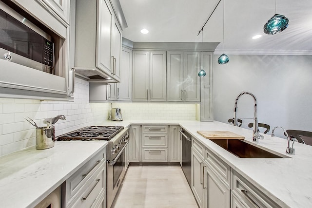 460 W Deming Pl Unit 1E, Chicago, IL 60614 - kitchen featuring stainless steel appliances, a sink, tasteful backsplash, decorative light fixtures, and light wood-style flooring