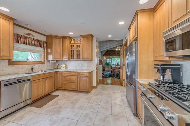 365 S Elm St, Itasca, IL 60143 - kitchen featuring appliances with stainless steel finishes, a sink, light tile patterned floors, light stone countertops, and backsplash