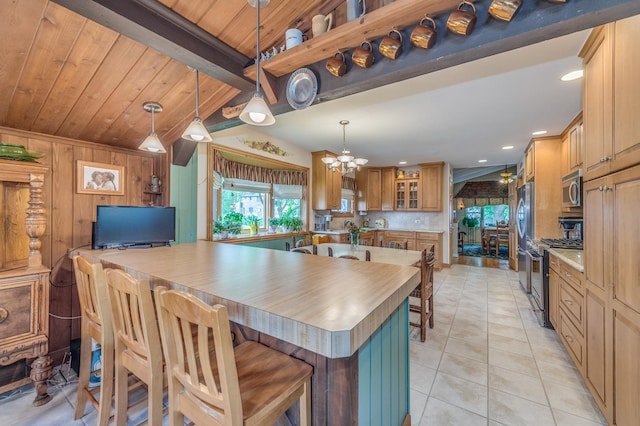 365 S Elm St, Itasca, IL 60143 - kitchen featuring appliances with stainless steel finishes, light tile patterned flooring, a breakfast bar area, decorative backsplash, and hanging light fixtures