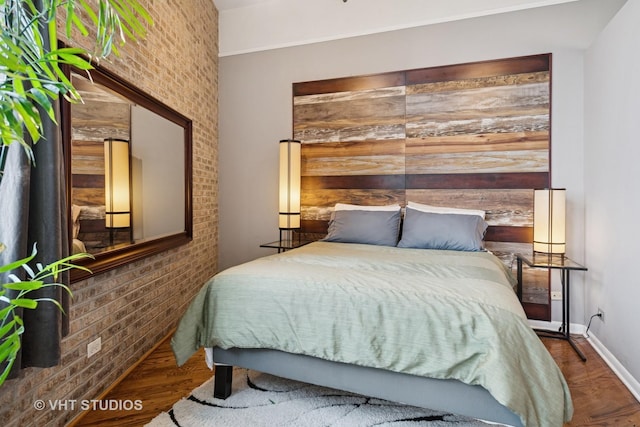 2222 W Diversey Ave Unit 407, Chicago, IL 60647 - bedroom featuring brick wall, baseboards, and wood finished floors