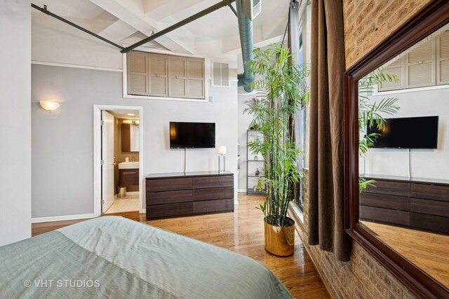2222 W Diversey Ave Unit 407, Chicago, IL 60647 - bedroom with wood finished floors, baseboards, ensuite bathroom, and a sink
