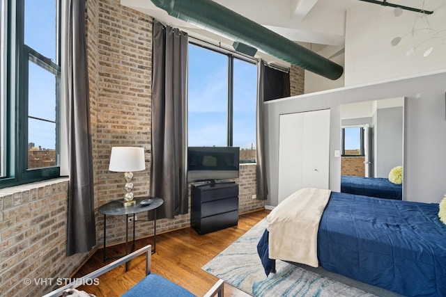 2222 W Diversey Ave Unit 407, Chicago, IL 60647 - bedroom with wood finished floors and brick wall