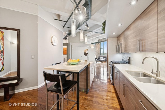 2222 W Diversey Ave Unit 407, Chicago, IL 60647 - kitchen featuring appliances with stainless steel finishes, a sink, light wood-style flooring, baseboards, and modern cabinets