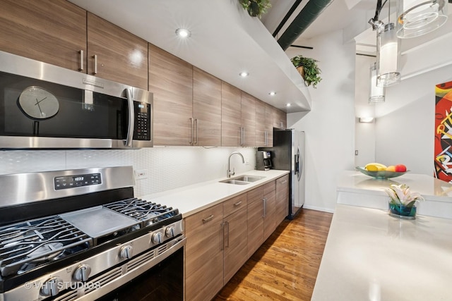 2222 W Diversey Ave Unit 407, Chicago, IL 60647 - kitchen featuring appliances with stainless steel finishes, a sink, light wood-style flooring, light countertops, and tasteful backsplash