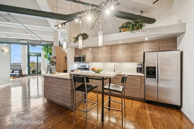 2222 W Diversey Ave Unit 407, Chicago, IL 60647 - kitchen with stainless steel appliances, a towering ceiling, brown cabinets, light countertops, and baseboards