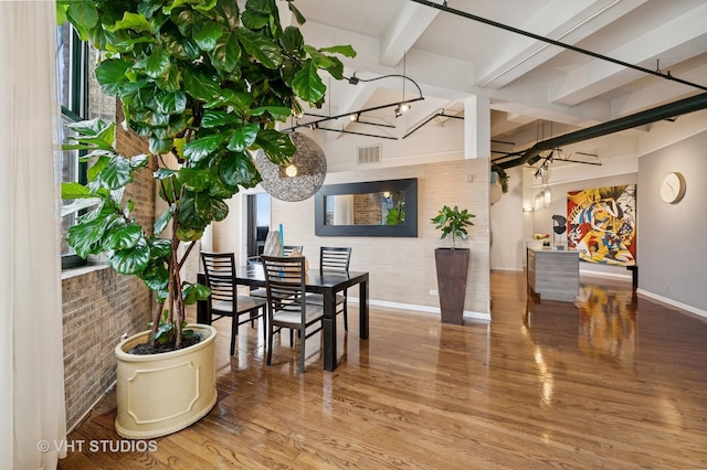 2222 W Diversey Ave Unit 407, Chicago, IL 60647 - dining area with baseboards, beam ceiling, wood finished floors, and brick wall