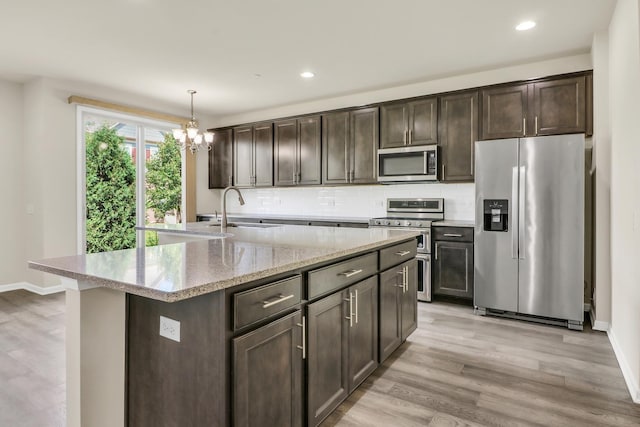 415 Highcroft Way, Lincolnshire, IL 60069 - kitchen featuring stainless steel appliances, a sink, a chandelier, dark brown cabinetry, and tasteful backsplash
