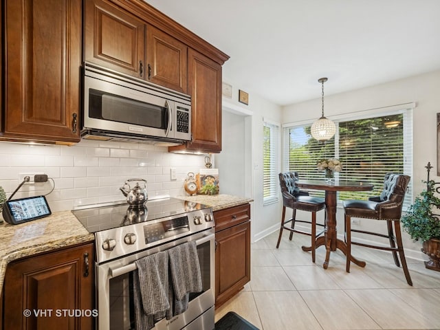 97 Thornhill Ln Unit D, Lake Barrington, IL 60010 - kitchen featuring stainless steel appliances, backsplash, baseboards, decorative light fixtures, and light tile patterned floors