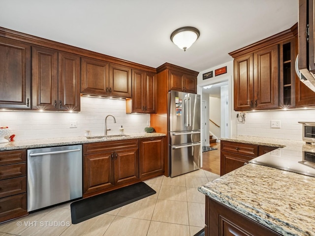97 Thornhill Ln Unit D, Lake Barrington, IL 60010 - kitchen featuring appliances with stainless steel finishes, a sink, backsplash, and light stone countertops